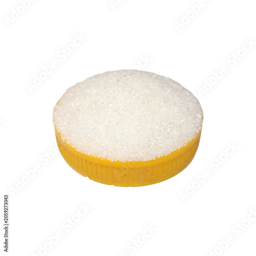 Yellow bottle cap filled with sugar crystals in diffused studio light