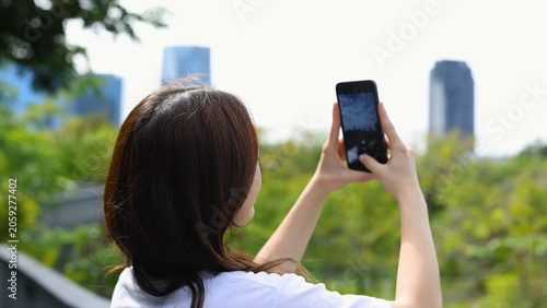 Canvastavla Young Woman Using Smartphone to Capture City Skyline in Benchakitti Park