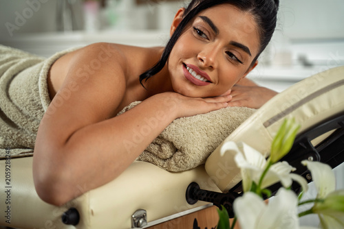 Closeup shot of attractive beautiful dark hair girl laying on the massage table 