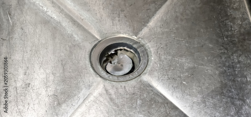 Slika na platnu A sink with a drain as water goes down the hole
