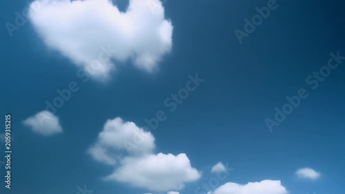 Time lapse of white cumulus clouds drifting across a vibrant blue sky on a sunny day. A scenic time lapse of soft white clouds moving smoothly across a bright blue sky.