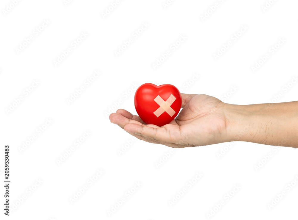 Obraz premium Hand holding red heart with adhesive bandage on white background.