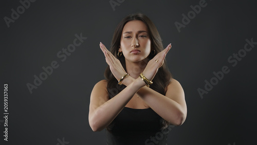 Quadro em tela Woman crossing hands in a stop gesture, showing disapproval and refusal