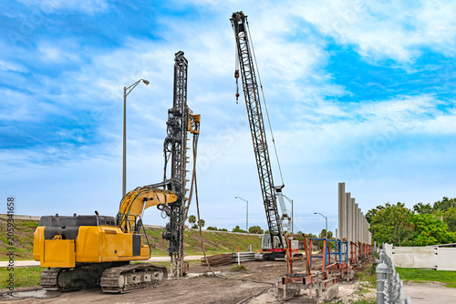 Quadro em tela Heavy drilling rig and lattice boom crawler crane installing concrete sound barr