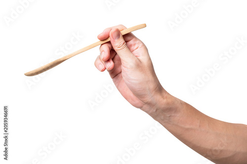 Male hand holding a wooden spoon isolated on white background.