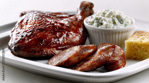 Smoked barbecue chicken leg quarter platter with jalapeno cheddar sausage and sides