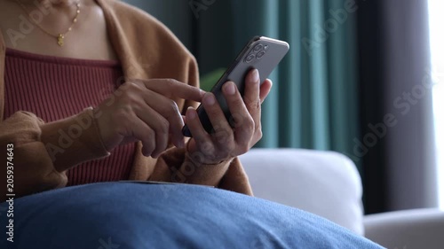 Asian mature woman using credit card booking ticket online on smartphone