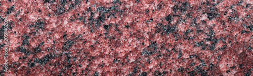 Deep red granite slab with black and grey mineral flecks, rough texture, natural stone