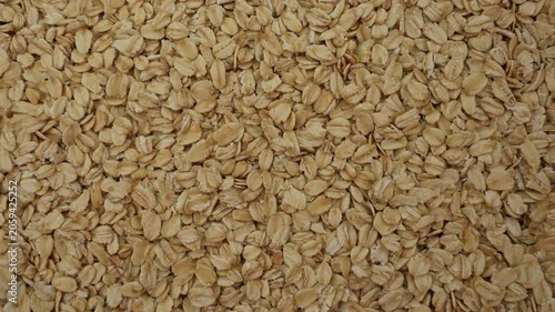 Rolled oats rotating top view. Dry oat flakes rotate.