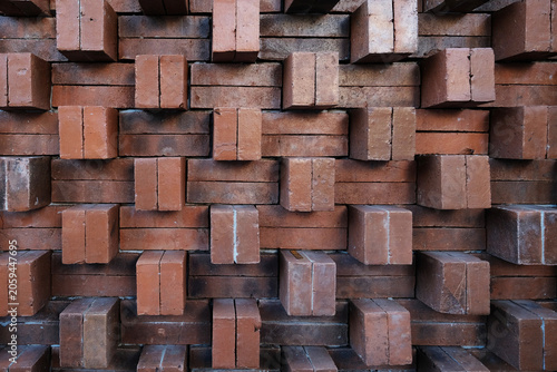 Obraz na plátně Decorative brick wall texture with protruding red clay bricks arranged in a geometric three-dimensional pattern