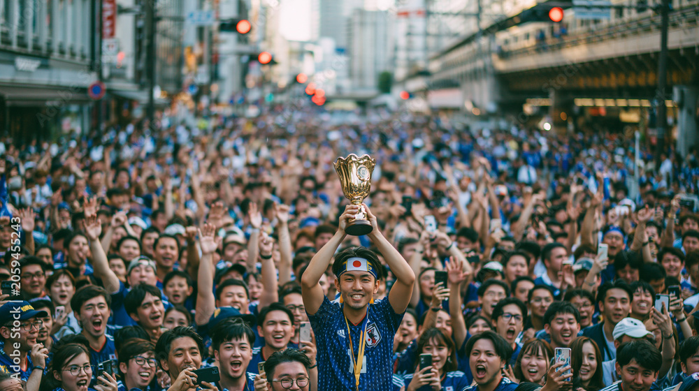 Obraz premium Victory Parade: A jubilant crowd cheers as a triumphant athlete, holding a golden trophy high, is celebrated in a vibrant street parade. The atmosphere is electric with excitement and national pride.