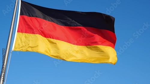 German flag waving against a clear blue sky