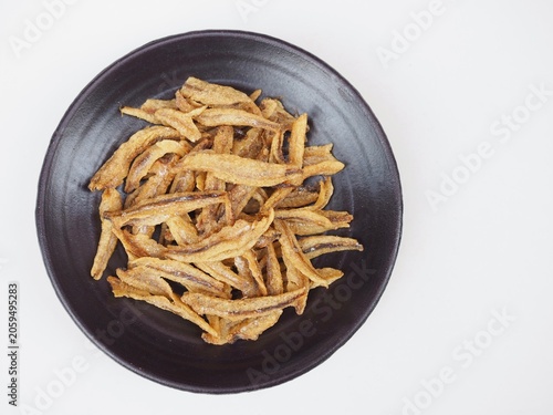 Quadro su tela Small, crispy baked fish are arranged on a plate on a white background