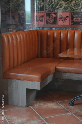 Empty orange leather booth seating in restaurant interior