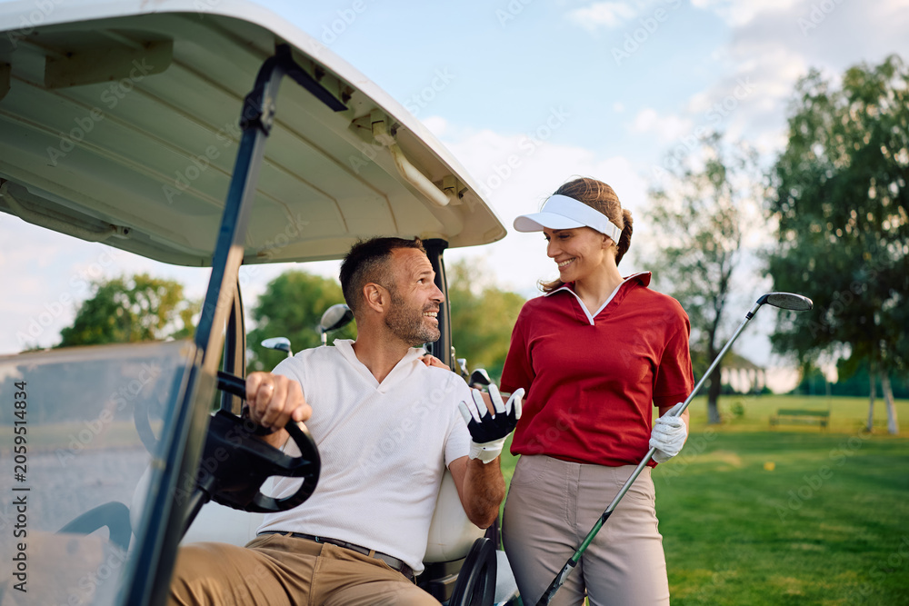 Naklejka premium Happy golfers talking while playing golf at the club.