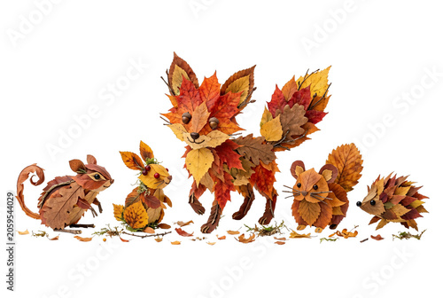 Five leaf-crafted woodland animals—squirrel, rabbit, fox, hamster, hedgehog—arranged in a row on a mossy autumn ground.