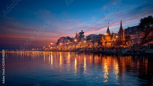 Illuminated Varanasi ghats reflected in Ganga river during Dev Deepawali festival at sunset