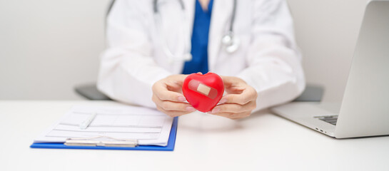 Doctor hand holding red heart shape in hospital. love, donor, world heart day, world health day, CSR donation and Insurance concepts