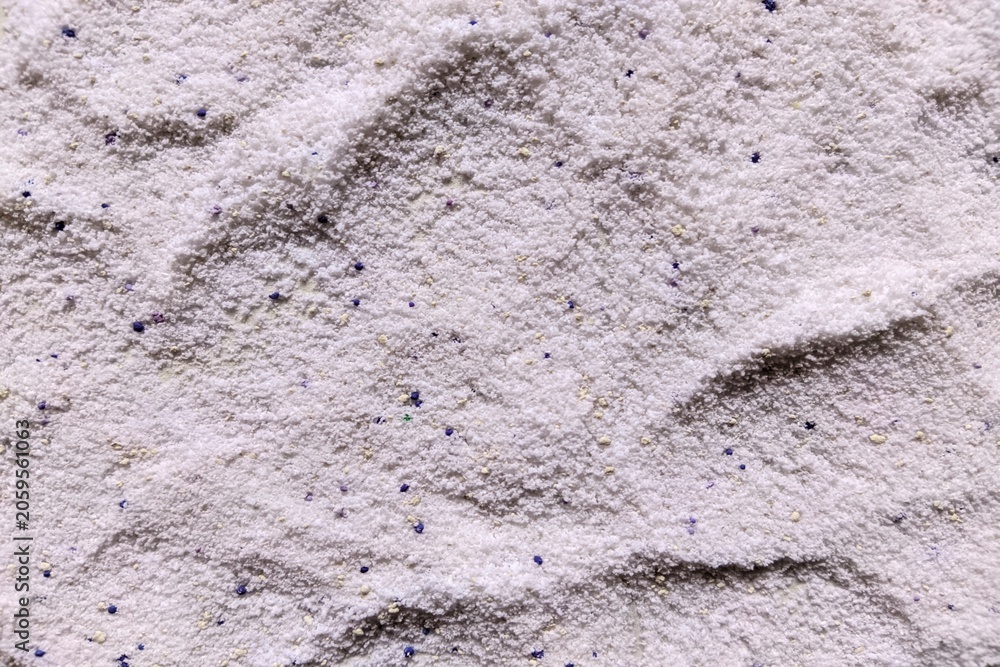 Fototapeta premium Top view close up of white laundry detergent powder texture with blue and yellow speckles
