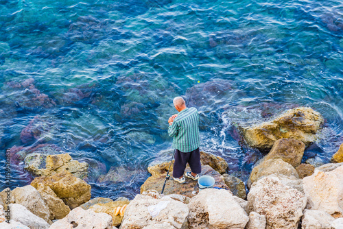 Fisherman catching fish at the beach at seaside