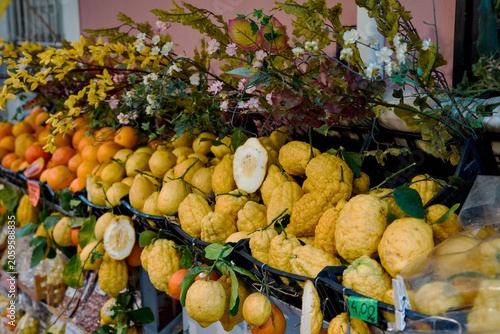 Slika na platnu Close up full frame of fresh organic lemons and giant Sicilian citrons (Cedro) with hand-written Euro price tag at a local outdoor market in Sicily, Italy