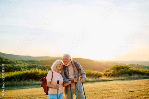 Senior couple hiking outdoors  embracing an active and healthy lifestyle together in the mountains at sunset