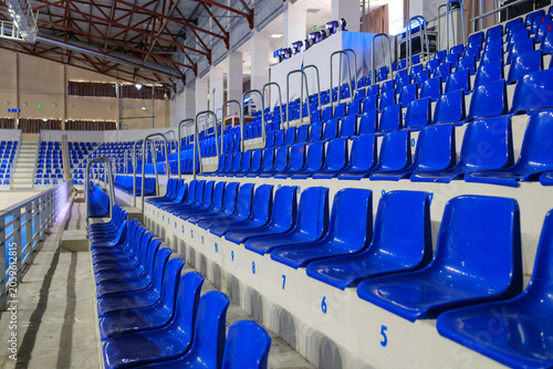 Konstfotografi Rows of empty blue plastic seats in an indoor sports arena stadium