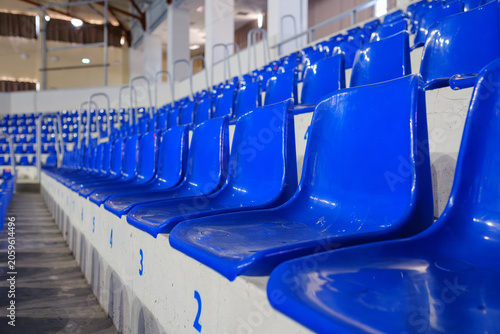 Konstfotografi Rows of empty blue plastic seats in an indoor sports arena stadium