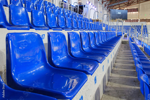 Canvastavla Rows of empty blue plastic seats in an indoor sports arena stadium