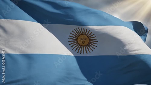 Argentina flag waving in the wind against a dramatic cloudy sky with sun rays shining
