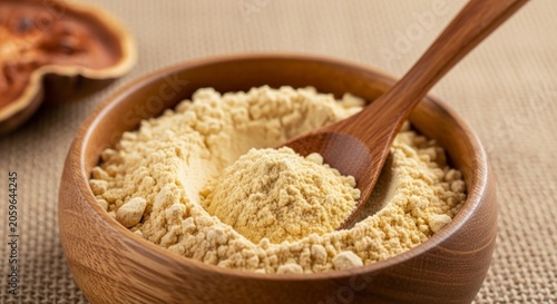 Earthy Wooden Bowl Filled with Golden Baobab Superfood Powder and Spoon.