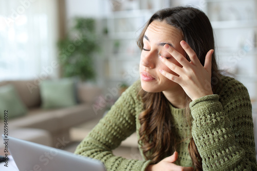 Fotografie Woman at home scratching itchy eye with her hand