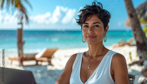 a professional brunette woman with short hair wearing a white summer dress sitting at the desk on the tropical beach on a sunny day, smart working photography