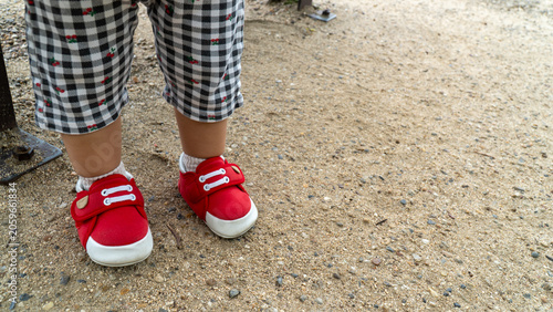 Φωτογραφία Toddler Standing in Red Shoes on Gravel Path with Copy Space