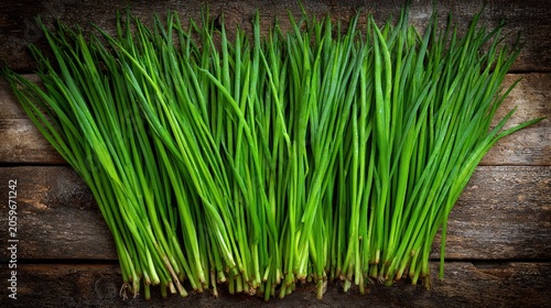 Freshly harvested green alliums are displayed atop dark, rustic wooden planks.