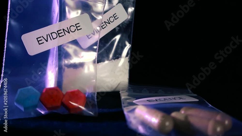 Different types of illegal substances, including ecstasy pills, cocaine powder, and capsules, seized by law enforcement and stored in transparent evidence bags against a black background