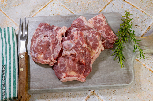 Colliers d’agneau crus isolés sur une planche à découper