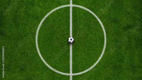 Soccer ball placed exactly in the center of the midfield line on a lush green professional stadium grass