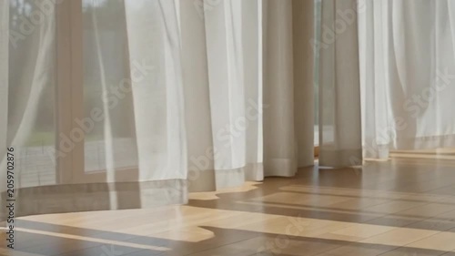 Soft wind moving white curtains inside minimalist meditation room.
