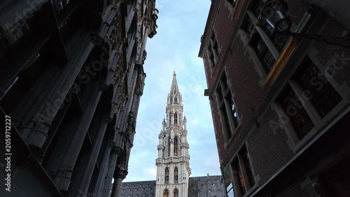 Grand Place Belgium sunset. Low-angle 4K video looking up at the majestic Gothic tower of the Brussels Town Hall between historic guild houses in the famous Grand Place market square.