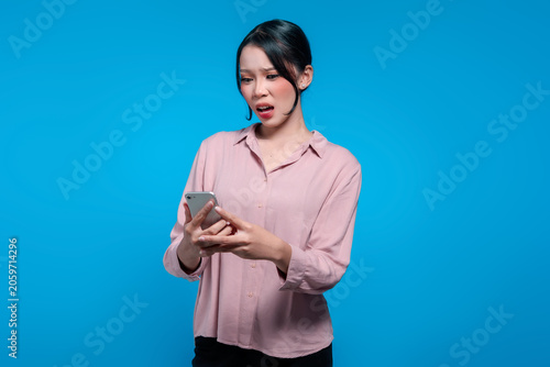Shocked Young Asian Woman Staring at Her Smartphone Screen