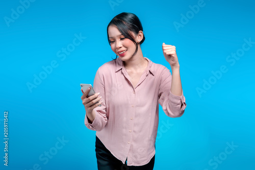 Excited Asian Woman Looking at Smartphone and Celebrating Success