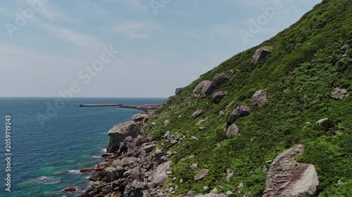 Close aerial shot of Okinoshima Island cliffs and blue ocean