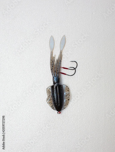 Squid-shaped rubber fishing lure with hook, white background.