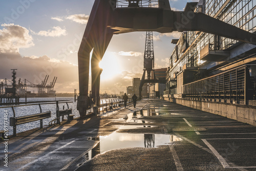 Diminishing perspective of wet footpath by Elbe River during sunset, Hamburg, Germany