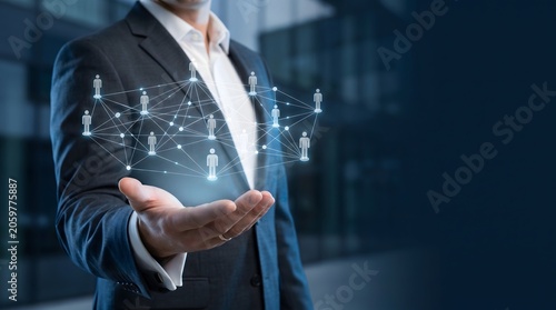 Businessman holds glowing network of people icons