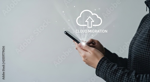 Person's hands holding smartphone showing cloud migration graphic with upload arrow during digital data transfer