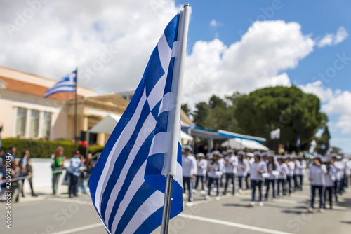 Obraz na płótnie Greek flag in front of brass band marching on Greek Independence Day parade in P