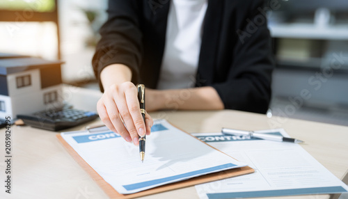 Fotografija Real estate broker agent presenting and consult to customer to decision making sign insurance form agreement, home model, concerning mortgage loan offer in office