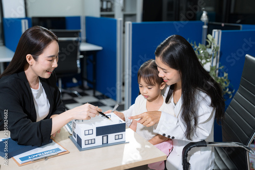 Foto Real estate broker agent presenting and consult to customer to decision making sign insurance form agreement, home model, concerning mortgage loan offer in office